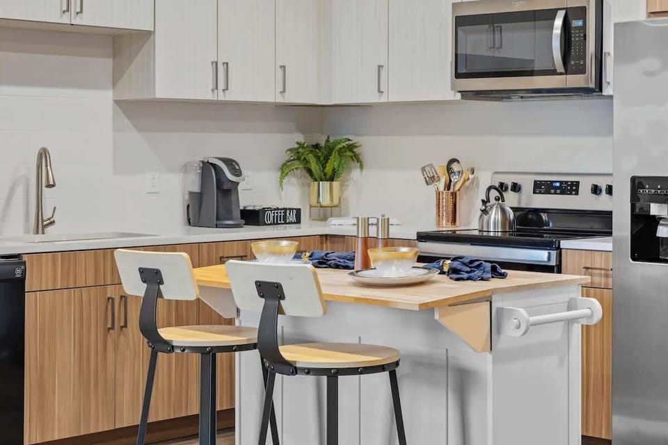 - Modern  shared kitchen with island seating and stainless appliances  
- Clean layout ideal for cooking dining and longer stays  
- Bright accents create a welcoming functional space  
