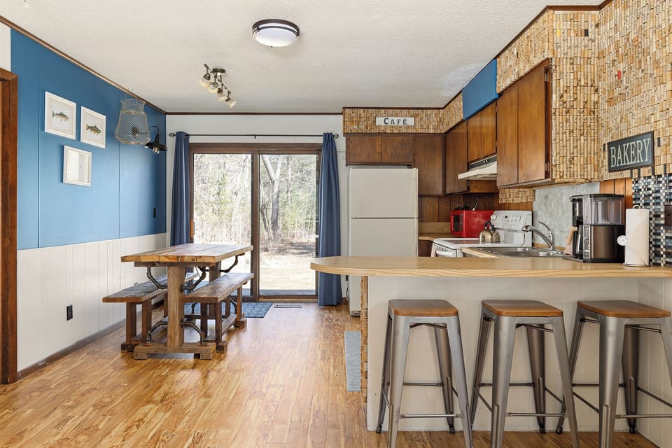 Open kitchen & dining area w/ breakfast bar seating & sliding doors to the yard.