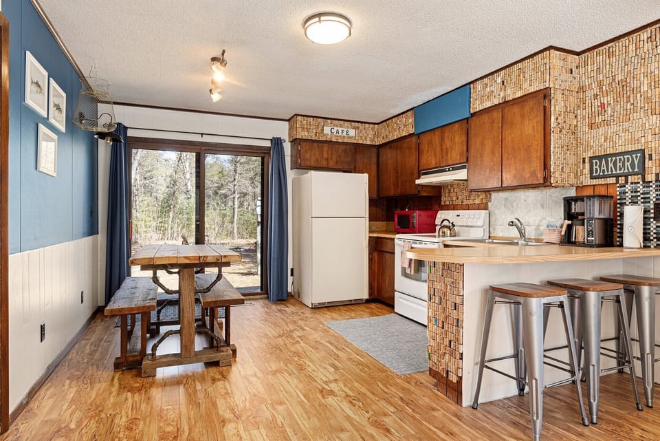 Open kitchen & dining space w/ wood finishes, breakfast bar & sliding door access.