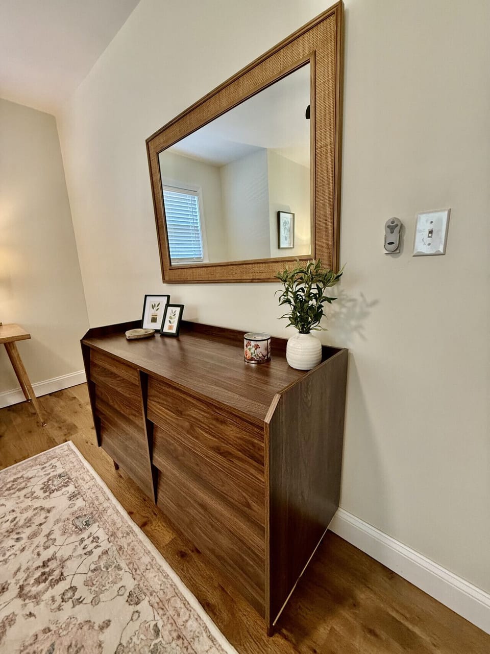 Modern dresser with large mirror and stylish decor, perfect for extra storage during your stay.