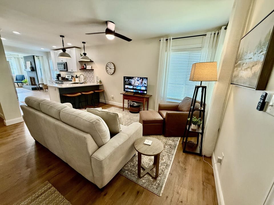 Cozy living area with smart TV, comfy seating, and open kitchen concept.