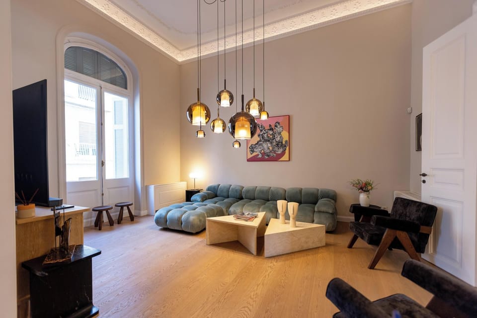 The living room features a 65" TV, a comfortable sofa, a soundbar, and 2 Marshall Speakers