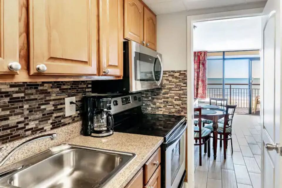The fully stocked kitchen is equipped with dinnerware, silverware, cookware, Oven, stove, microwave, full-sized refrigerator, sink, and plenty of cabinet storage options for whipping up your culinary delights.