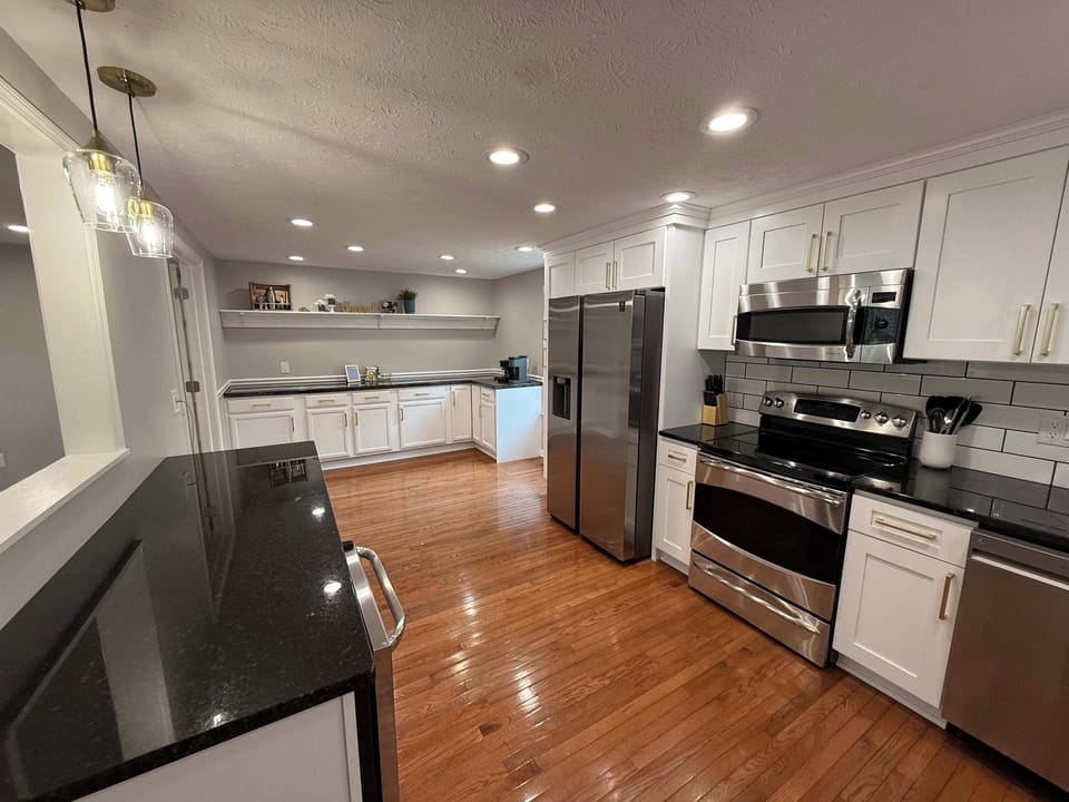 Large kitchen with different types of coffee makers, beverage fridge, electric range and many additional appliances in the cabinets. Essentials for cooking provided. Cast-iron skillet.