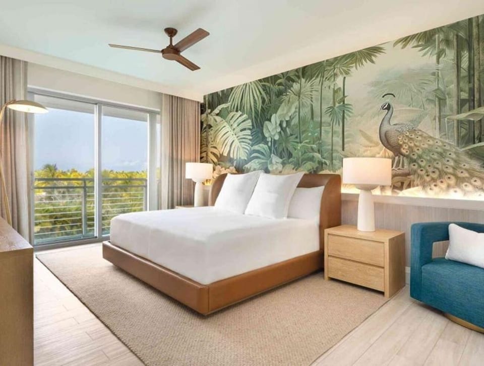Sink into crisp linens beneath a stunning tropical feature wall.