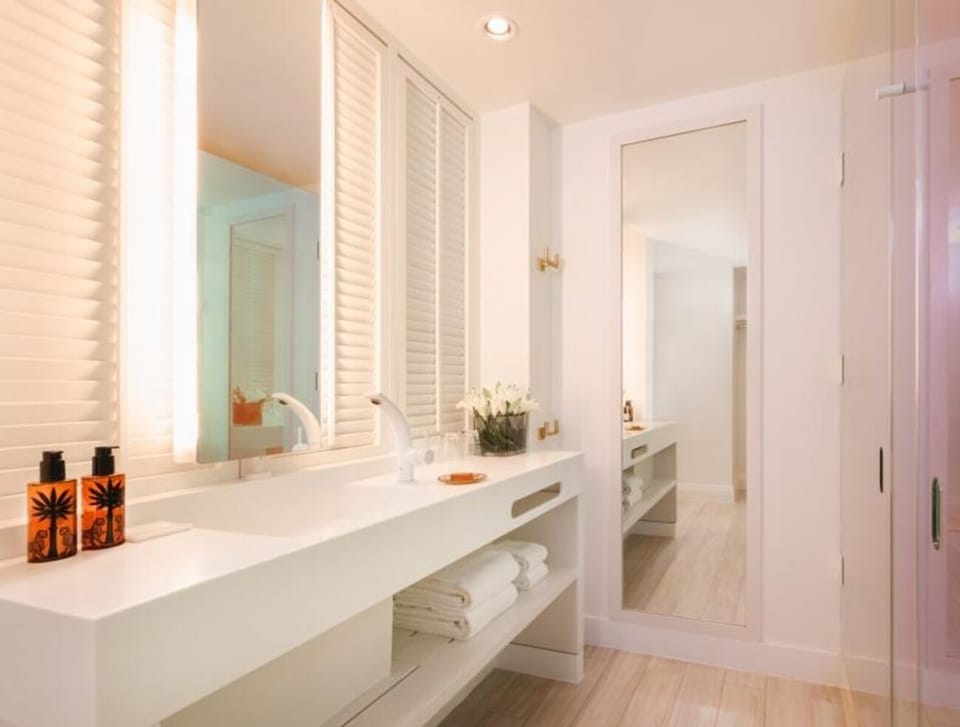 Refresh at the sleek double vanity with soft, spa-like lighting.