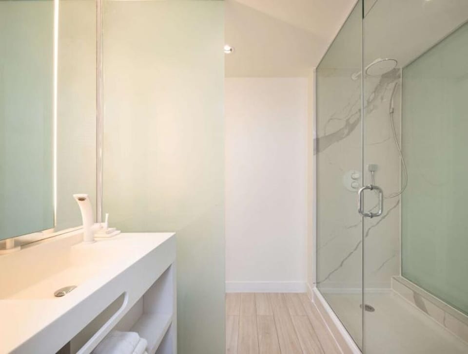 Rinse off in the glass walk-in shower, spa-bright.
