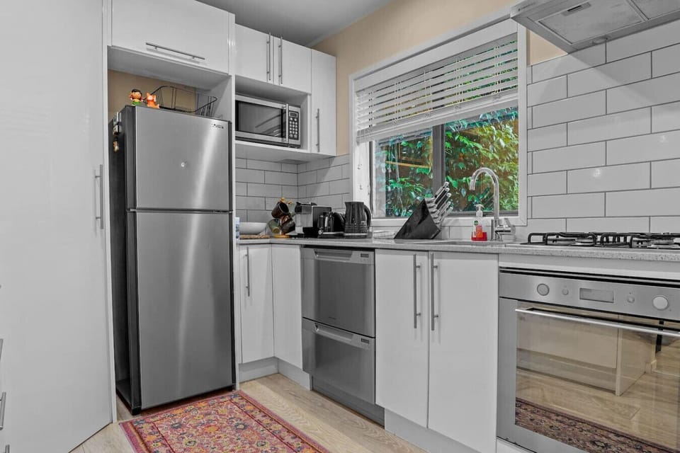 The kitchen has an oven, cooktop, microwave, dishwasher and fridge/freezer.