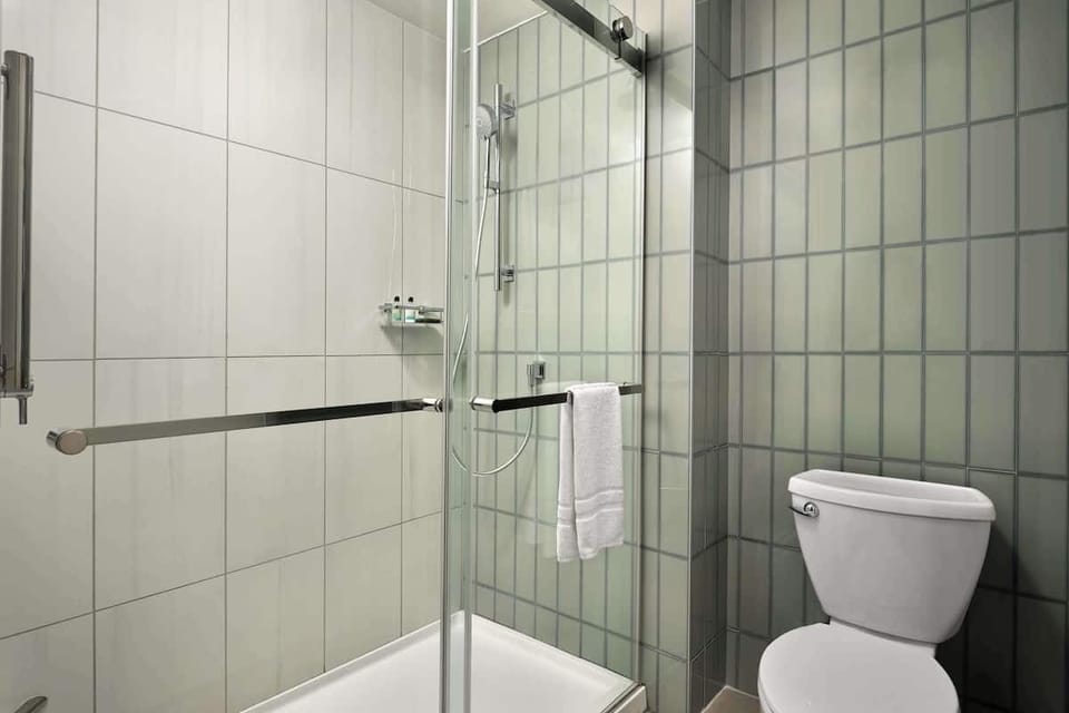Refresh under a spacious glass shower with bright lighting.
