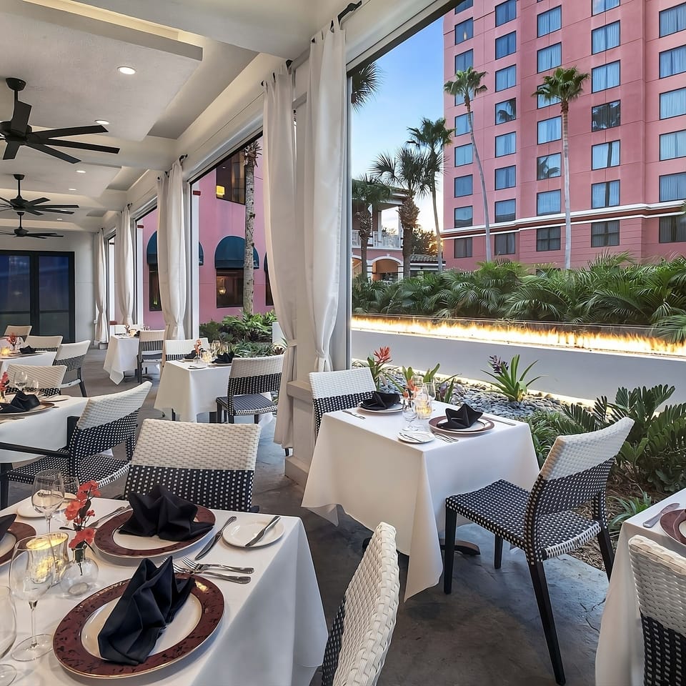 Dine alfresco under breezy fans with beautifully set tables.