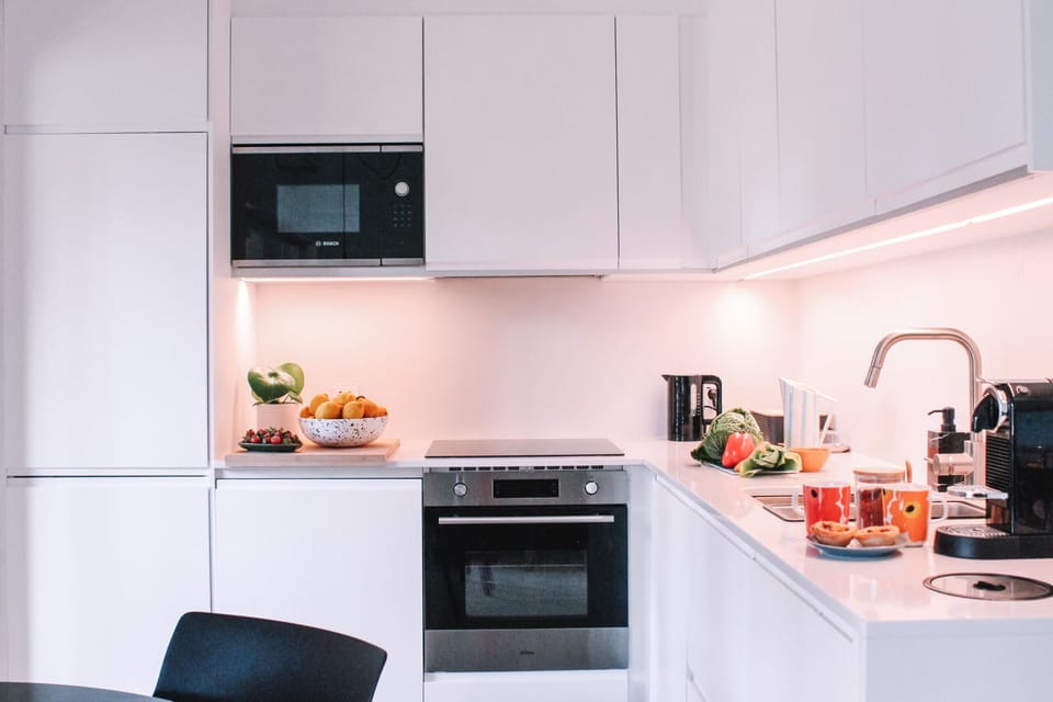 Modern white kitchen with ambient lighting and built-in appliances — Greenview Golf Apartment, holiday apartment in Portugal