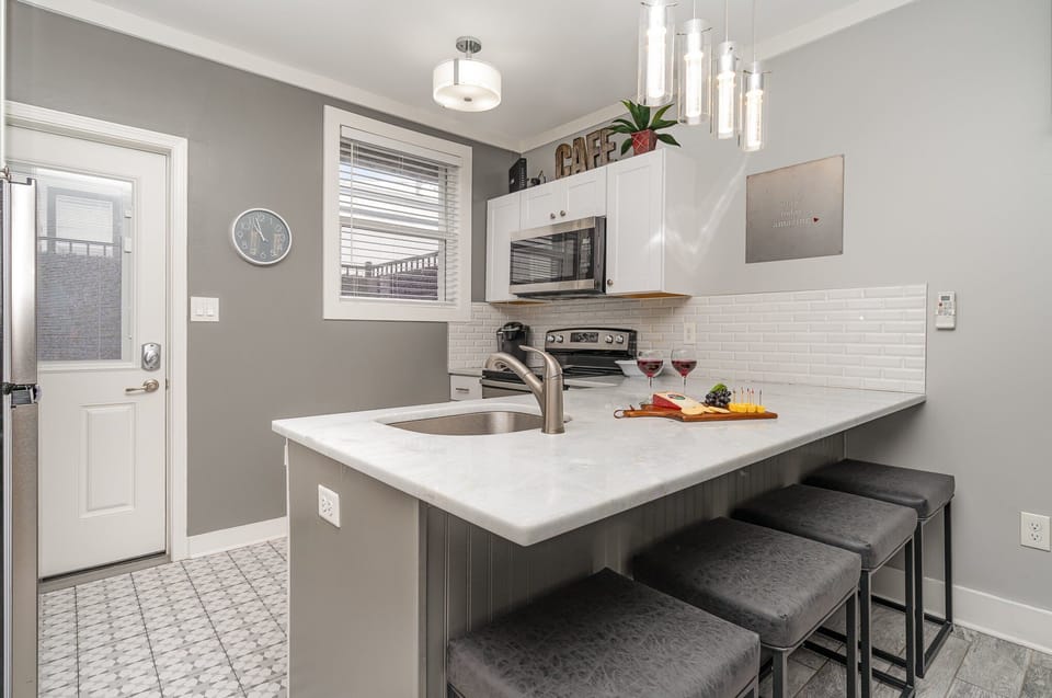 2nd Unit: The fully equipped kitchen features culinary essentials, stainless steel appliances, and a kitchen island with bar seating for 4 guests.