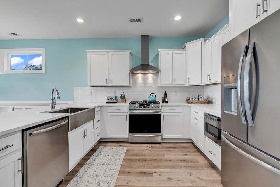 A modern kitchen with stainless steel appliances and clean white cabinetry.