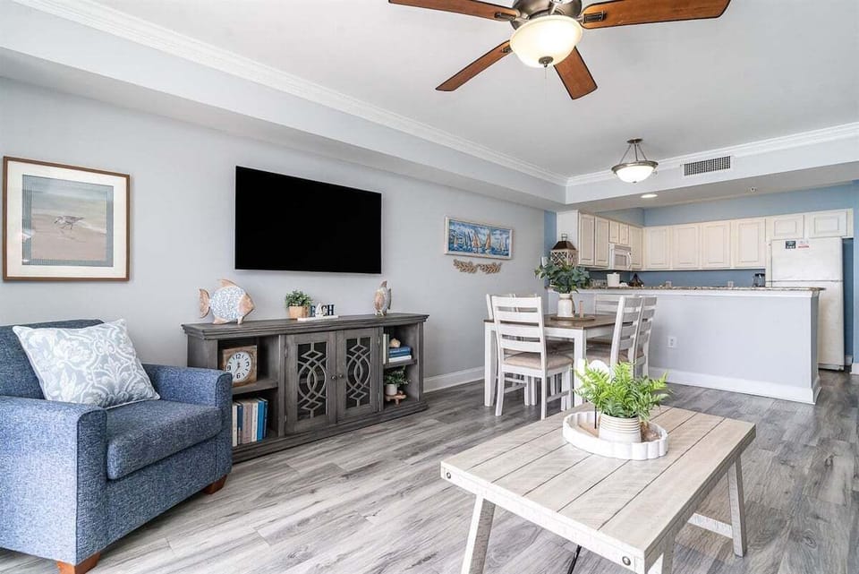 Comfortable living space with seating, TV, and an easy flow into the dining and kitchen areas.