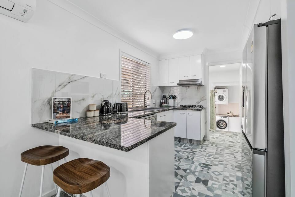 Whip up everything from laid-back breakfasts to evening favourites in the fully equipped kitchen, complete with an oven, dishwasher, and a stone benchtop with bar seating for relaxed bites.