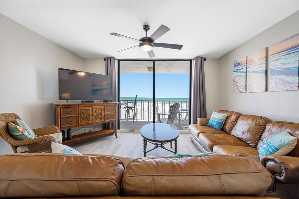 Spacious and inviting living area with plush seating and direct access to the balcony overlooking the ocean.