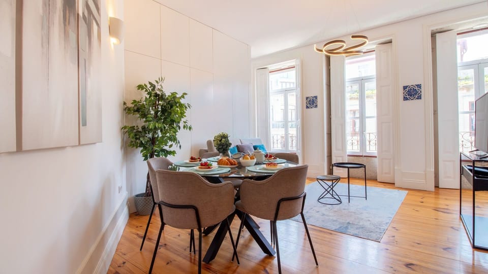 Gather around the elegant dining table for memorable meals, perfectly complemented by natural light from the large windows and a touch of greenery that brings the outdoors in.
