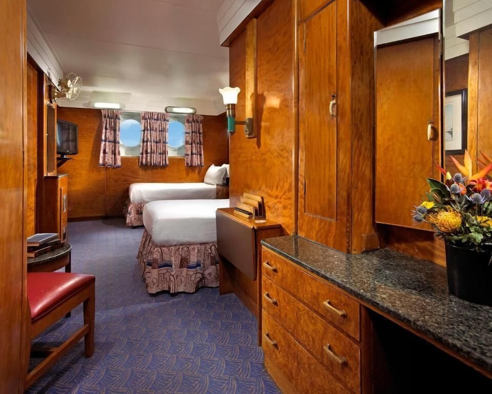 Unwind in cozy twin beds with warm wood-paneled charm.