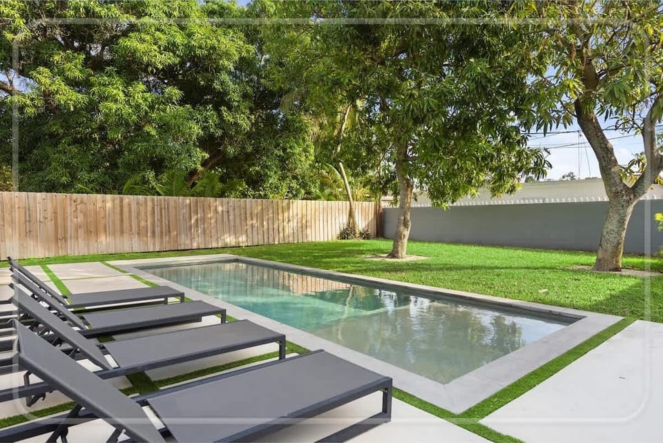  Welcome to the social heart of the home! This stunning open-plan living area is designed for entertainment, with a sleek pool table, a comfortable lounge area, and a dining space all in one. 
