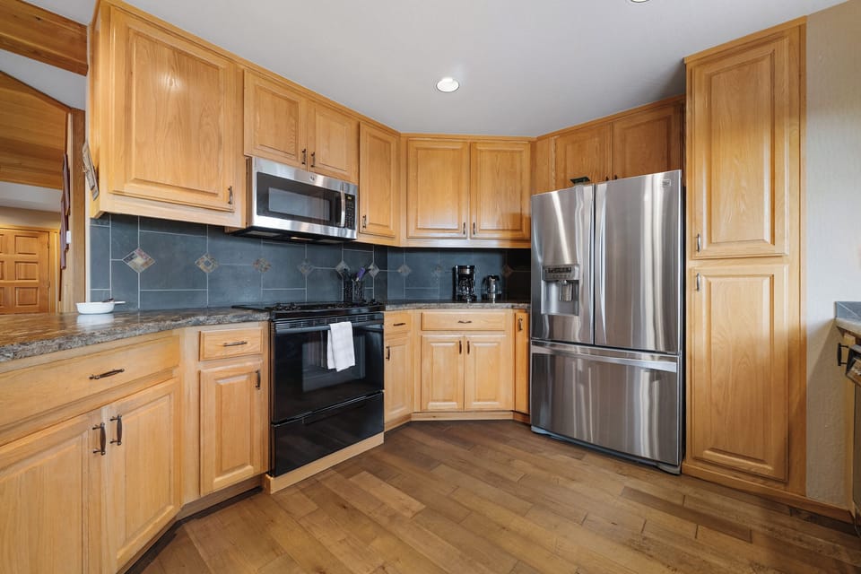 The open kitchen features granite countertops and stainless steel appliances