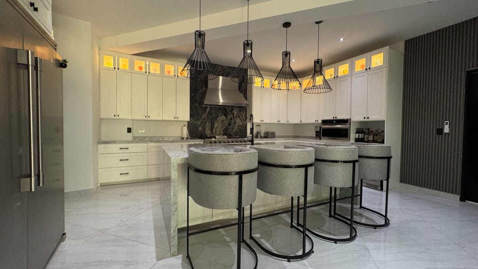 gourmet kitchen with huge island, fridge, oven and stove top, beverage fridge 