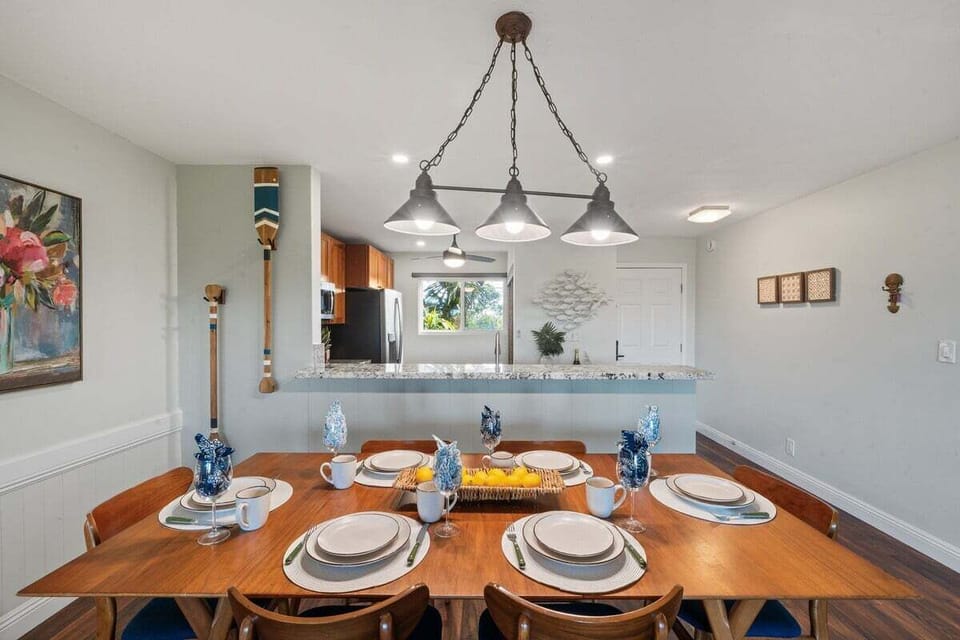Bright dining area with chandelier lighting, seating for six, and open access to the patio for indoor-outdoor dining.