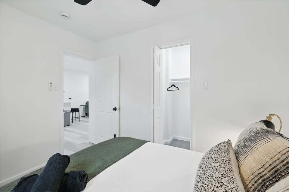 “Queen Bedroom in Unit 2 with Workspace” Rest easy in this bright queen bedroom featuring blackout curtains, a ceiling fan, and a dedicated desk — perfect for work or relaxation.