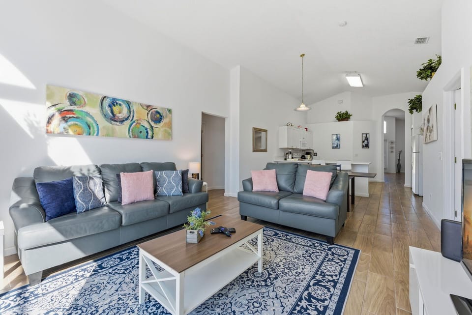 Harmonic and pleasant living room with a soothing blue wall and a stylish leather couch set.