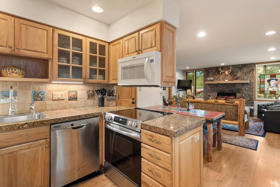 Enjoy cooking in a fully equipped kitchen featuring granite countertops, stainless steel appliances, and custom wood cabinetry—perfect for preparing m