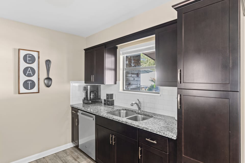 Sleek kitchen with dark wood cabinetry and modern countertops.