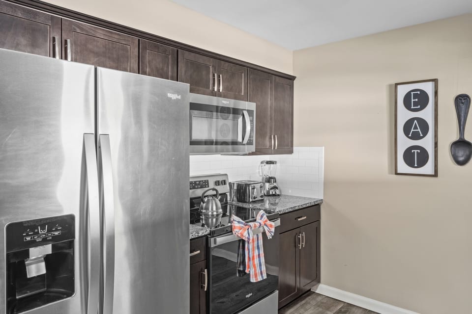 Fully equipped modern kitchen with stainless steel appliances.