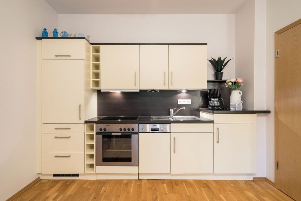 Modern kitchen with white cabinets and stainless steel appliances.