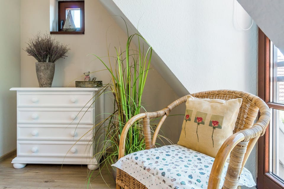 Bright living area with rattan chair and cabinet