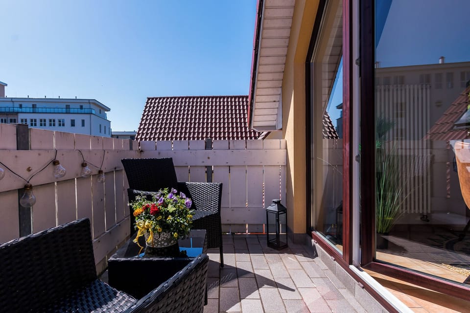 Terrace with two chairs and flower pot.