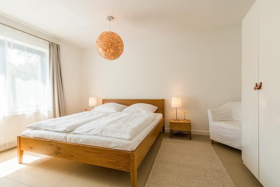 Bright bedroom with double bed and armchair