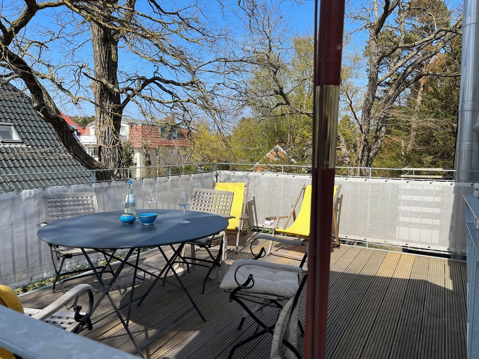 Terrace with table and chairs in green surroundings