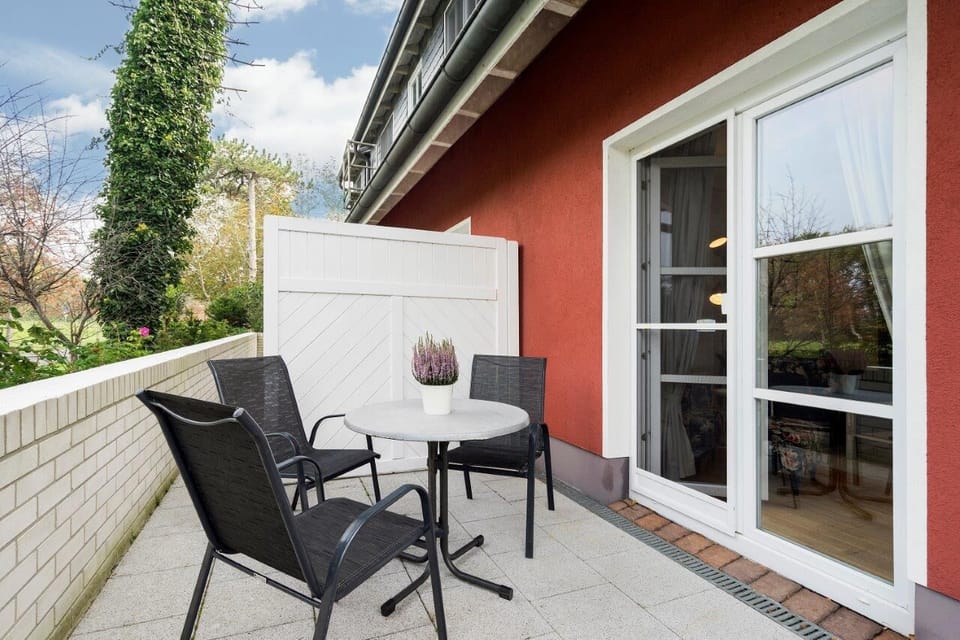 Terrace with table and chairs surrounded by plants