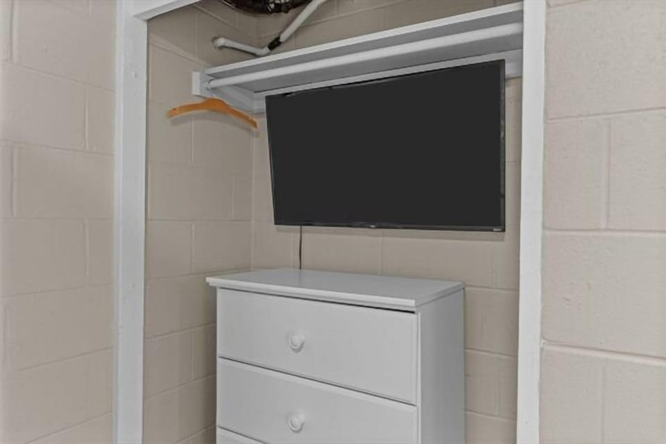 Your spacious walk-in closet combines smart storage with entertainment—a wall-mounted TV and dresser keep you organized and entertained while getting ready.