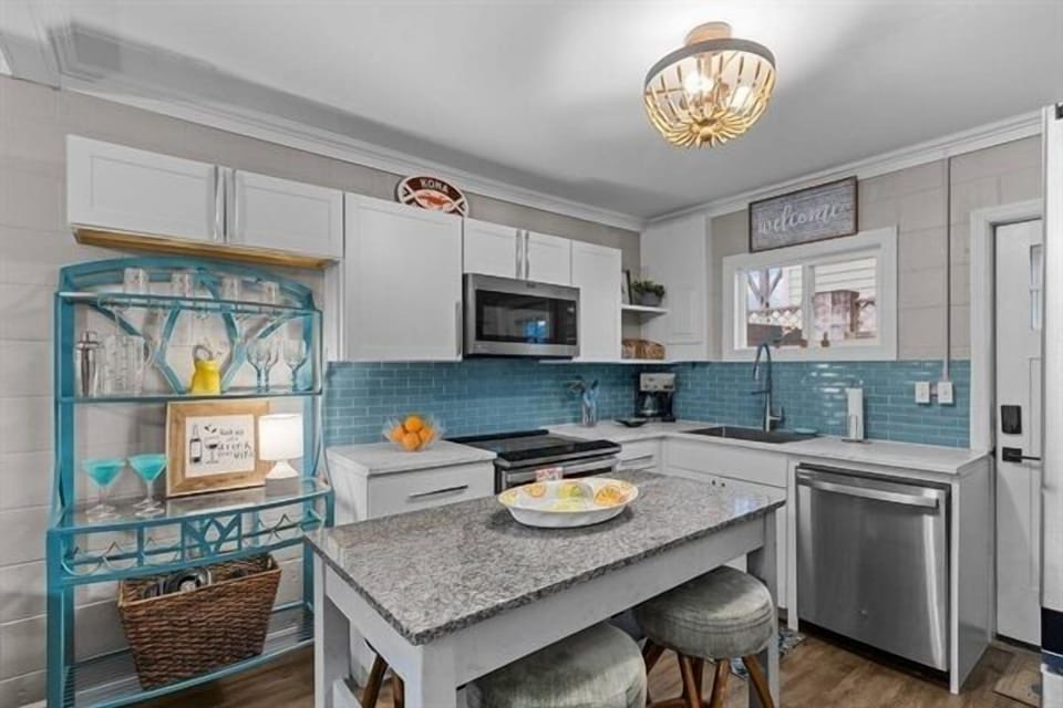 Your fully equipped kitchen awaits with granite counters, stainless appliances, and charming turquoise accents for memorable meal preparation.