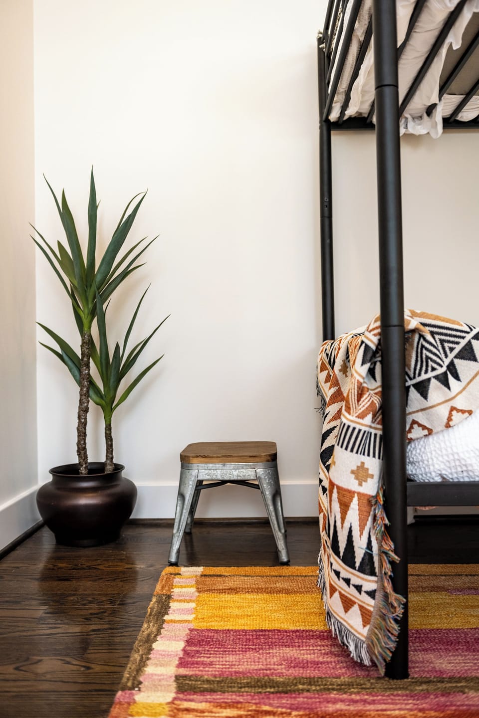 Designed for comfort and character, this bedroom blends boho-chic vibes with modern touches. The warm tones, textured blanket, and rustic accents create a space that feels both inviting and unique.