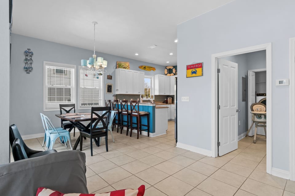 Step into your bright, coastal-themed space where turquoise accents and nautical touches create the perfect beach getaway atmosphere for memorable meals together.