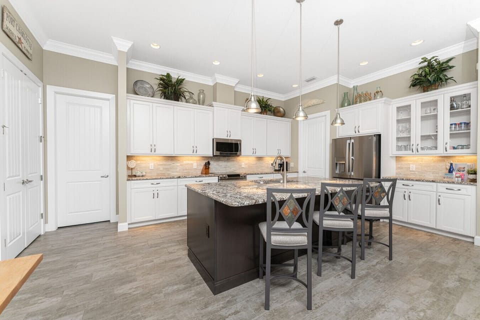 Fully stocked kitchen with generous countertops, cabinets, stove, microwave, freezer, and coffee maker in this Englewood waterfront home