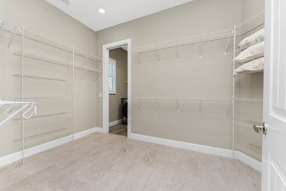 Spacious walk-in closet with ample storage and organization space at Aqua Circle Tides House