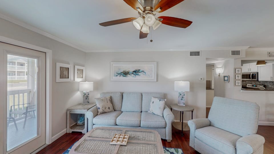 Enjoy comfortable, plush seating in the living room while you relax in the tranquility of its simple coastal decor.