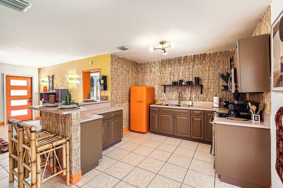 fully-loaded kitchen with stove, microwave, full fridge