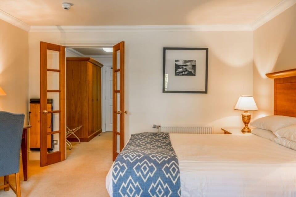 Unwind in a spacious bedroom with crisp linens and warm lamps.
