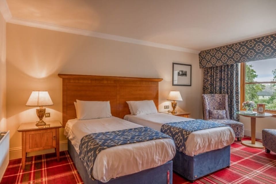 Drift off in comfortable twin beds with cozy bedside lighting.