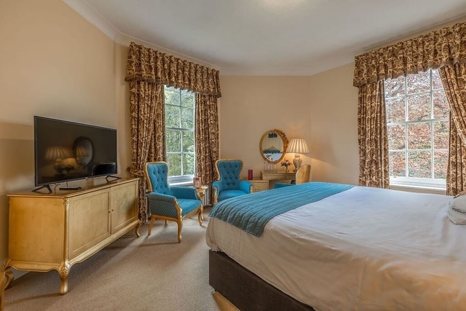 Unwind in a spacious bedroom with classic décor and TV.