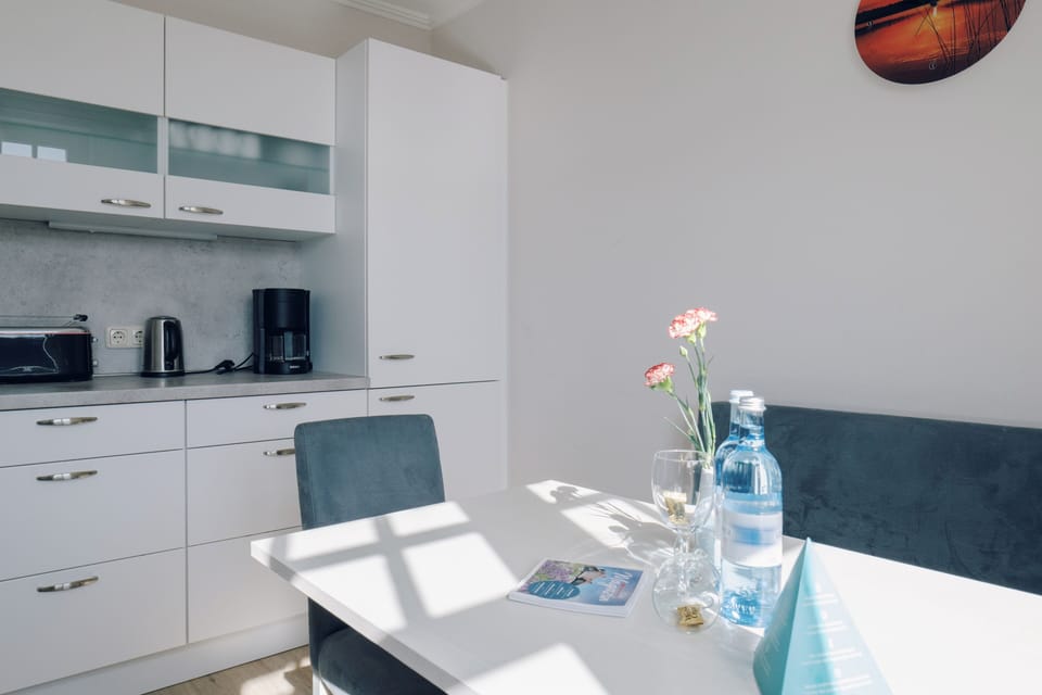 Bright kitchen with a table and a bouquet of flowers.