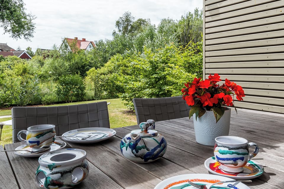 Terrace with table, dishes, and blooming plants